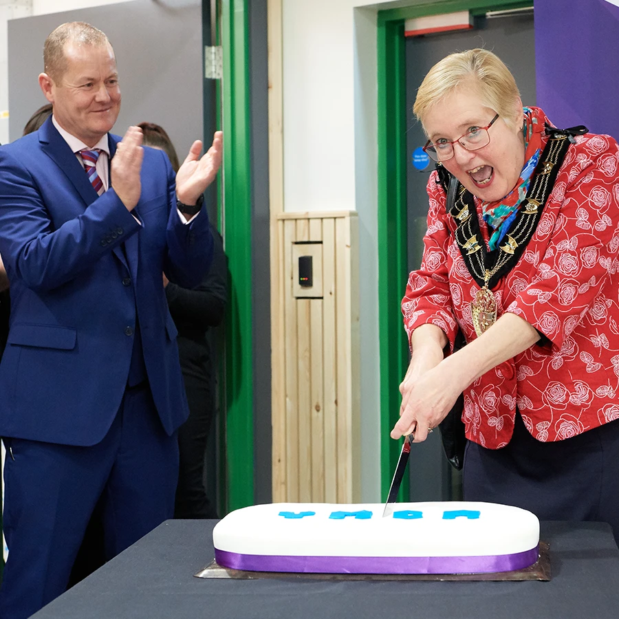 Mayor cutting a celebration cake at a corporate event